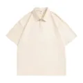 Close-up detail of the classic lapel and button placket on this solid color beige polo shirt. - S / Apricot