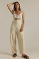 Detailed view of the casual beige loose overalls with side pockets and buttons in studio setting. - S / Ivory