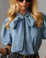 Detailaufnahme einer Damen-Jeansbluse mit stilvollem Schleifenkragen und eleganten Puffärmeln. - S / Oberteile / Blau