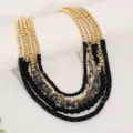 Primo piano di una collana multi-strato bohémien con perline dorate e pietre naturali - Stile X-1377 / Nero