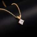 Close-up shot of a delicate gold chain necklace featuring a sparkling square cut pendant. - Gold Square Zirconia Style (DZ12262)