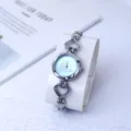 Elegante Damen Quarzuhr mit herzförmigem Armband und süßem Schaukelpferd Zifferblatt. - Silber & Blau