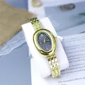 Detail shot of vintage oval gold watch with dark roman numeral dial and steel strap. - Black