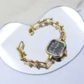 Close-up of luxury square dial women watch with gold chain link bracelet elegant design details. - Black