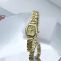 Detailweergave van een gouden dameshorloge met quartz-uurwerk, tonvormige wijzerplaat en schakelarmband. - Goud