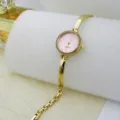 Close-up detail of women's gold quartz bracelet watch with pink dial and sparkling crystal bezel. - Pink