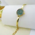 Women gold bracelet quartz watch with dark green dial and rhinestone bezel accessory. - Green