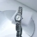 Close-up of a women's quartz watch with tonneau dial and silver metal link bracelet. - Silver