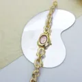 Detailansicht der goldenen unregelmässigen Kettenuhr mit pinkem Zifferblatt und Design Detail. - Gold Rosa