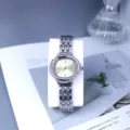 Detailed shot of a silver rhinestone women quartz watch with a golden dial and metal strap. - Light Yellow