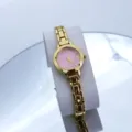 Dettaglio orologio da polso donna dorato con elegante quadrante rosa e cinturino metallico. - Oro e Rosa