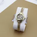 Nahaufnahme der goldenen Damenuhr mit schickem Leoparden-Zifferblatt und mehrsträngigem Armband. - Leopardenprint