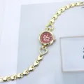 Detaillierte Nahaufnahme der goldenen Damenuhr mit Herzgliedern und rotem Zifferblatt. - Rot