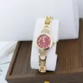 Close-up of women's quartz watch featuring a red dial, gold bracelet, and rhinestones. - Red