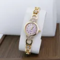 Elegant gold quartz wristwatch featuring a pink dial and sparkling rhinestone bracelet details. - Pink