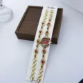 Detailaufnahme von Damen Quarzuhr und Armband Set in Gold mit roten Strasssteinen auf Karte. - Rot