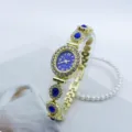 Detailansicht der goldenen Damen-Quarzuhr mit blauem Zifferblatt und Zirkonias. - Goldblau