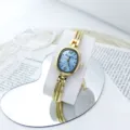 Vista detallada del elegante reloj de cuarzo con esfera ovalada pequeña y correa de cadena. - Azul cielo