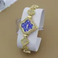 Montre quartz femme trèfle strass dorée vue détaillée, cadran bleu montre bracelet élégante. - Bleu