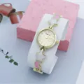 Primo piano dettaglio dell'orologio da polso donna con stelle e luna, quadrante chic. - Rosa con quadrante dorato