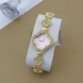 Vue detaillee d une montre femme strass trefle de luxe avec cadran rose et bracelet or. - Rose