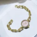 Gold quartz watch for women with pink dial, rhinestone bezel and unique chain bracelet detail. - Pink