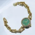 Detailansicht der luxuriösen Quarzarmbanduhr mit grünem Zifferblatt und Metallarmband. - Grün