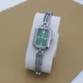 Elegant women's quartz watch with a sleek silver bangle strap and dark green rectangular dial. - Silver Green