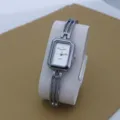Women's silver bracelet quartz watch featuring a small square dial and unique multi-line strap detail. - Silver White