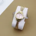 Detailansicht einer filigranen Damen-Quarzuhr mit goldener Kette und rosafarbenem Zifferblatt. - Gold & Rosa