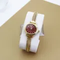 Nahaufnahme der eleganten goldenen Damen Quarzarmbanduhr mit rotem strukturiertem Zifferblatt. - Gold Rot