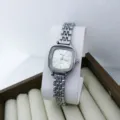 Vue detaillee d'une montre quartz pour femme compacte avec cadran carre et bracelet metal. - Argent Blanc