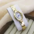 Close-up of golden oval quartz watch with Roman numerals and dazzling rhinestones on band. - Gold White