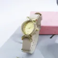 Vista detallada de un elegante reloj de cuarzo ovalado para mujer con correa de nailon. - Albaricoque
