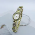 Detailaufnahme einer feinen goldenen Damen-Quarzuhr mit ovalem Strass-Zifferblatt und Kristall. - Gold Weiß