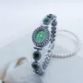 Nahaufnahme der eleganten ovalen Quarz-Armbanduhr in Grün mit funkelnder Strass-Lünette. - Silber Grün