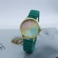 Detailed shot of a stylish quartz watch with gradient rainbow dial and green stretch band. - Green