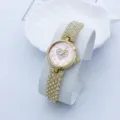 Nahaufnahme einer luxuriösen Strass-Quarzuhr für Damen mit rosafarbenem Zifferblatt und Armband. - Gold & Rosa