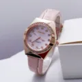 Vista detallada de reloj de cuarzo para mujer con correa de cuero rosa y bisel con pedrería. - Rosa
