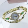 Vue détaillée montre bracelet quartz femme dorée avec cadran strass et pierres vertes élégantes. - Vert