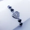 Close-up of elegant heart-shaped quartz watch with stylish black crystal links and silver finish. - Silver Black
