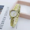 Close-up detail of luxury gold women rhinestone quartz watch with elegant vintage strap texture. - White