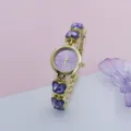 Gedetailleerde close-up van het stijlvolle paarse kristallen vlinder quartz horloge. - Goud Paars