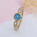 Close-up detail of the women rhinestone quartz watch with starry dial and gold bracelet. - Gold Blue