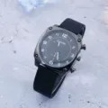 Black square dial quartz watch with silicone strap detail view showing clear numerical markers. - Black