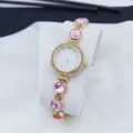 Women quartz watch with pink gemstones and rhinestones, elegant gold-tone fashion detail. - Pink