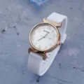 Women white silicone strap quartz watch with rose gold case and digital dial detail shot. - White