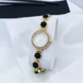 Detail view of women vintage gold quartz bracelet watch with sparkling rhinestones and black beads. - Black