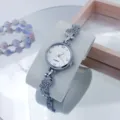 Zilveren quartz horloge voor dames met sprankelende strass vlinderbedels en een elegante wijzerplaat. - Zilver