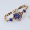 Detailweergave van het gouden dameskwartshorloge met blauwe hartkristallen en armband. - Roségoud Blauw